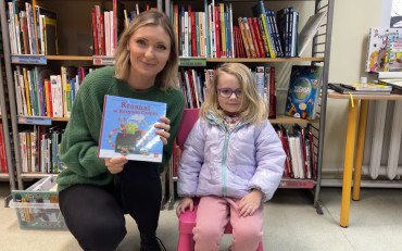 Mała czytelniczka z bibliotekarką pozują do zdjęcia