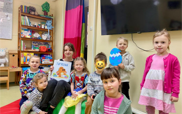 Dzieci i bibliotekarka z książeczką